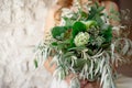 Slightly disheveled fresh and airy bridal bouquet with a grinn ball, brunia, eringum, eustoma, asparagus and eucalyptus in the