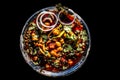 Slightly high angle shot of a glass plate full of Chole bhature in it on a black background along with some phudina/mint chutney a