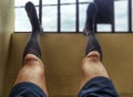 Legs with long stockings and dark shorts on the base of a balcony Royalty Free Stock Photo