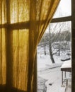 a slightly open yellow curtain on the window with a view of winter street Royalty Free Stock Photo