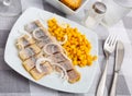 Slightly salted herring slices with pickled corn and fresh onion