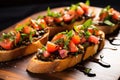 slightly tilted shot of bruschetta with truffle oil on platter