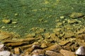 Slightly undulating, purely crystalline water in a mountain lake and submerged granite rocks