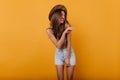 Slim adorable girl laughing and looking away on yellow background. Indoor portrait of stunning female model with Royalty Free Stock Photo