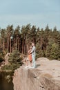 Slim appealing girlfriend leaning on her strong man standing on the rock