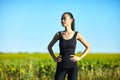 Slim athletic Asian woman resting in field in summer day