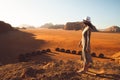 Slim beautiful caucasian woman tourist stand on cliff barefoot watch sunrise and enjoy holiday vacation in Wadi rum panorama by