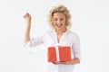 Slim beautiful young blonde girl holding a red gift box in her hands while standing against a white background. Concept