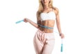 Slim body, jump rope. Girl with perfect waist with a jump rope in hands. Athletic slim woman measuring her waist by Royalty Free Stock Photo