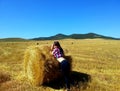 Woman posing with haystack on mowing field Royalty Free Stock Photo