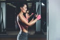 Slim, bodybuilder girl, does the exercises standing in front of the mirror in the gym.