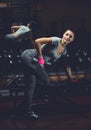 Slim, bodybuilder girl, lifts heavy dumbbell standing in front of the mirror while training in the gym. Royalty Free Stock Photo