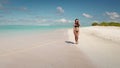 Slim brunette woman in bikini walk barefoot beach Royalty Free Stock Photo