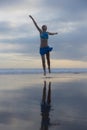 Slim Caucasian woman jumping on the beach. Active lifestyle. Fit and healthy. Happiness and freedom. Young female wearing blue Royalty Free Stock Photo