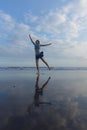 Slim Caucasian woman jumping on the beach. Active lifestyle. Fit and healthy. Happiness and freedom. Young female wearing blue Royalty Free Stock Photo
