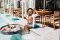 Slim excited girl with long blonde hair posing at resort. Summer portrait of magnificent woman enjo