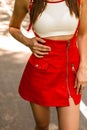 Slim female body in fashionable white top in red vintage short skirt outdoors. Close-up