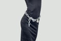 Slim figure girl in black dress. Metal chains on the lock around the waist. Slavery, exploitation of people, lack of freedom, Royalty Free Stock Photo