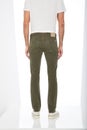 Slim fit army green trousers paired with white T-Shirt and white sneakers with white background