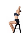 Slim fit girl on chair bends to right studio shot Royalty Free Stock Photo