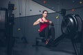 Slim fit muscular brunette woman exercise in gym, lifting weights and doing pilates. Picture with dark evening mood and film color