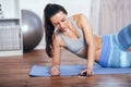 Slim fitness young woman doing exercise at home with smartphone Royalty Free Stock Photo