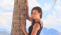 Slim girl in black frock touches palm looks up into sky