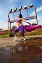 Slim girl dancing with kerchief on roof