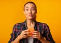 Girl Eating Burger Having Cheat Meal Standing On Yellow Background