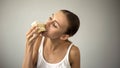 Slim girl eating cake eagerly, dieting and starving, lack of self-discipline Royalty Free Stock Photo