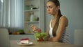 Slim girl eating salad but craving cake, fashion trend to be slender, diet