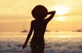 Slim girl with hat at sunset beach Royalty Free Stock Photo