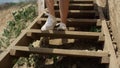 Slim girl legs running down beach staircase wearing white sneakers close up. Royalty Free Stock Photo