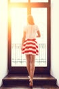 Slim girl in short skirt going out to the balcony Royalty Free Stock Photo