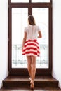 Slim girl in short skirt going out to the balcony Royalty Free Stock Photo