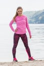 Slim girl in sporty clothes exercising on beach at sea, healthy active lifestyle on fresh air Royalty Free Stock Photo