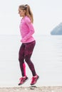 Slim girl in sporty clothes exercising on beach at sea, healthy active lifestyle Royalty Free Stock Photo