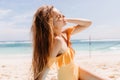 Slim girl with straight dark hair relaxing at beach in sunny morning. Photo of magnificent european