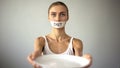 Slim girl with taped mouth showing empty plate, severe diet and self-destruction