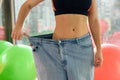 Slim girl wearing oversized pants in gym
