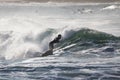 Slim male surfing on foamy high waves splashing in the sea