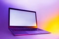 Slim modern laptop with white screen on the background creative light. Mockup in colorful bright neon UV blue and purple lights Royalty Free Stock Photo