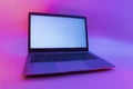 Slim modern laptop with white screen on the background creative light. Mockup in colorful bright neon UV blue and purple lights Royalty Free Stock Photo