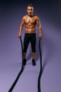 Slim muscular man training with battle rope Royalty Free Stock Photo