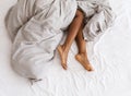 Slim, perfect and beautiful crossed woman legs on bed at vacation and holiday Royalty Free Stock Photo