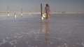 Slim girl enjoying a sunset, gently walks on the water of a salt lake
