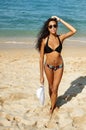 Slim tanned beautiful young woman with sporty body relaxing on a summer beach