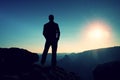 Slim tourist on sharp peak of rocky mountain is watching over misty and foggy morning valley to Sun Royalty Free Stock Photo