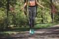 Sporty lady is hopping over rope in nature