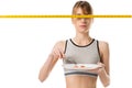slim woman eating cherry tomato with measuring tape in front her eyes Royalty Free Stock Photo